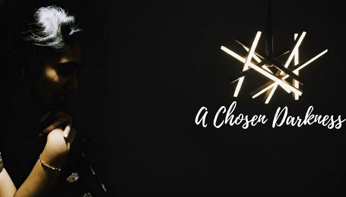 A person walking in a dark valley with a single light source.